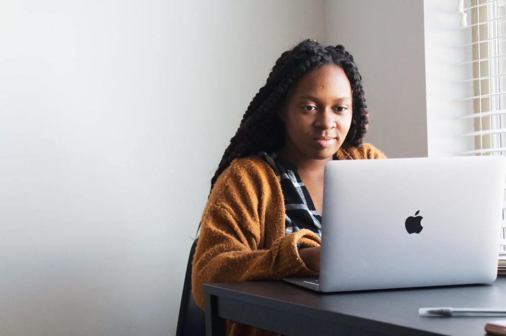 image of a black woman typing on a laptop