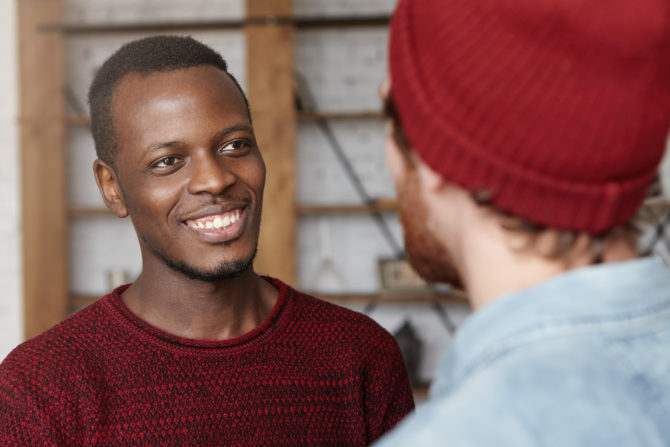 Image of a white man talking to a black man after moving to the UK