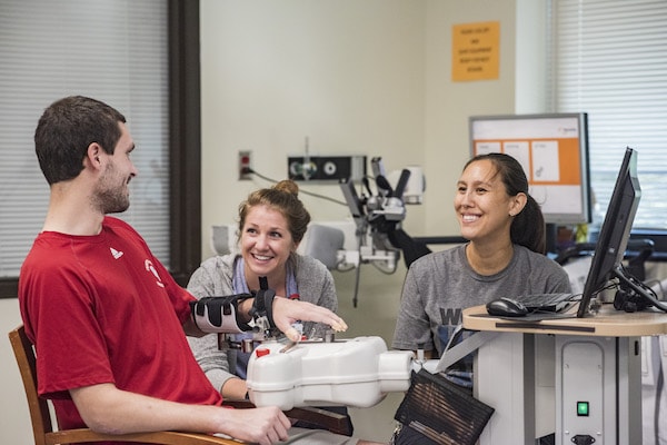 Image of healthcare assistants helping a man as jobs in New Zealand with visa sponsorship