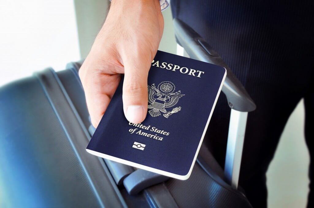Image of a man with a New Zealand visa waiver showing his passport at the airport