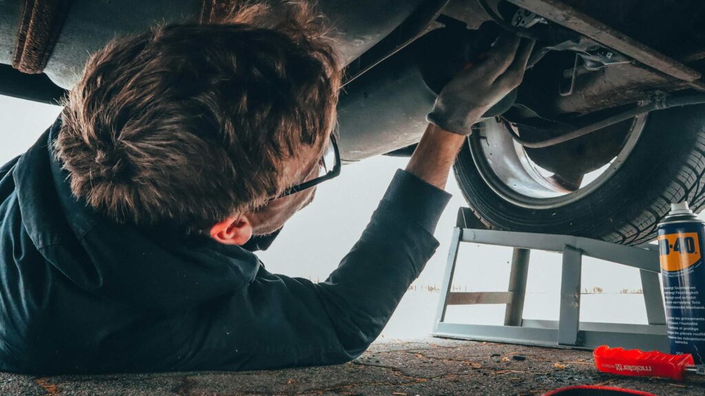 Image of an automotive service operator working on a car