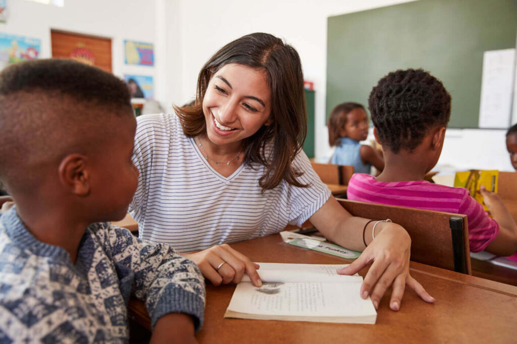 Image of a teacher correcting mistakes done by a pupil in class