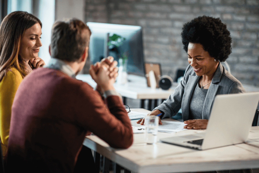 Image of a black woman attending to 2 customers