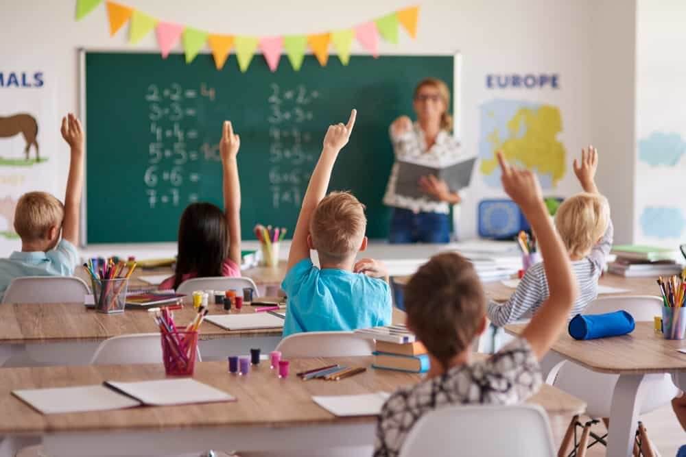 Image of a qualified teacher moderating over a class in UK