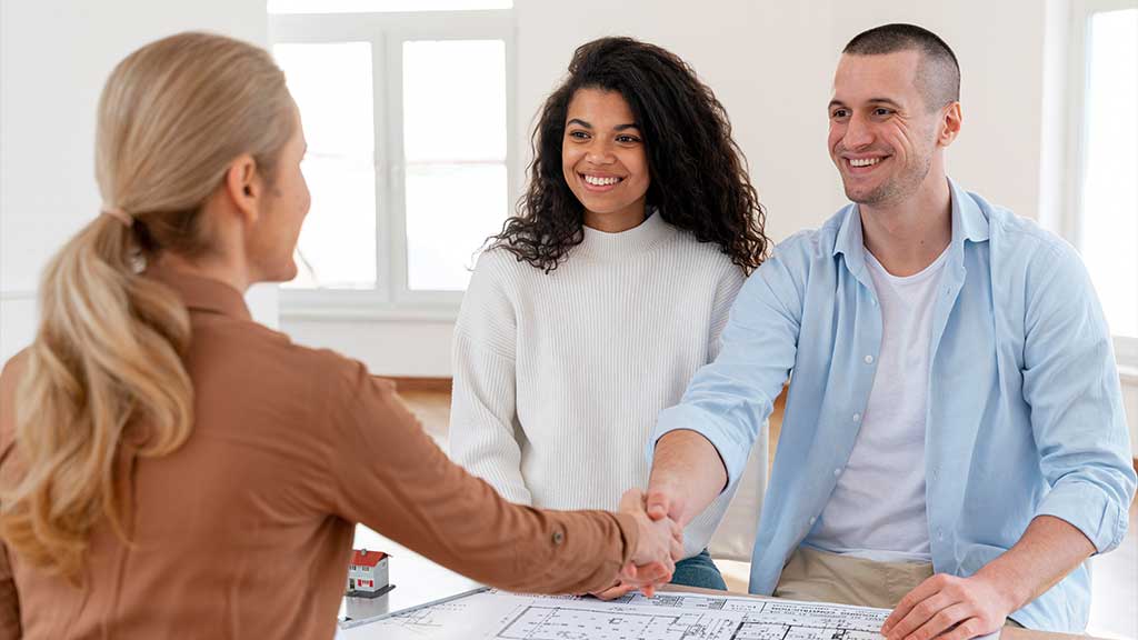 Image of a couple negotiating with a property representative to get cheap housing in the UK