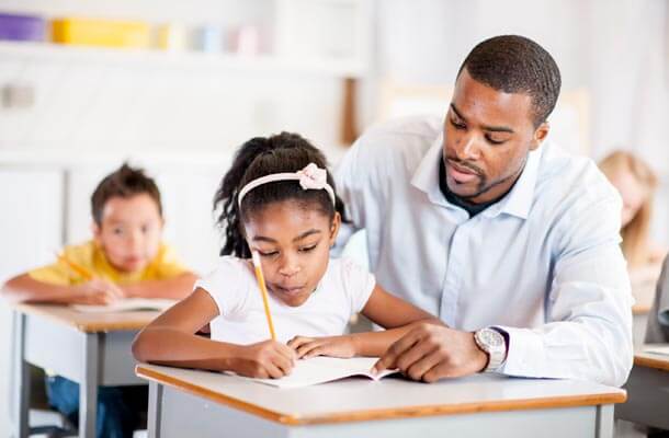 Image of a teacher in the UK coaching a pupil in class