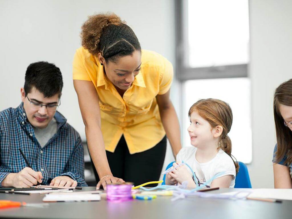 Image of a teacher with special needs and abilities teaching pupils