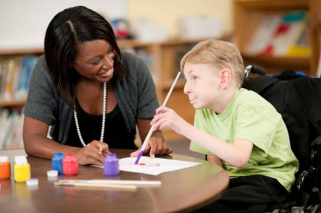 Image of a school teacher teaching a special child