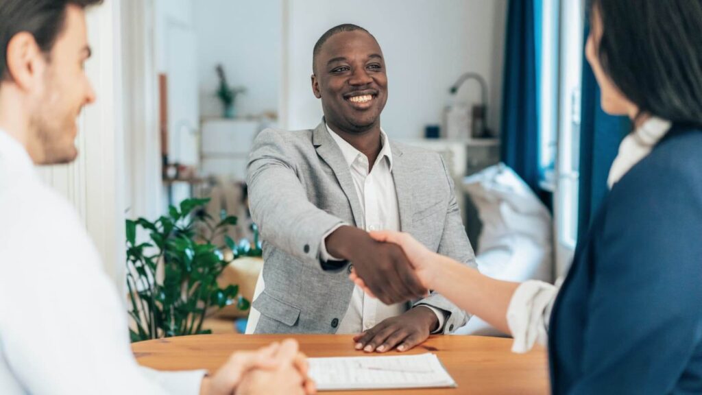 Image of a black man being congratulated for getting offered a job after moving to Sweden