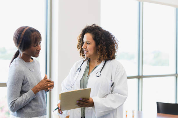 Image of a medical consultant who is a beneficiary of UK visa sponsorship jobs talking to a patient