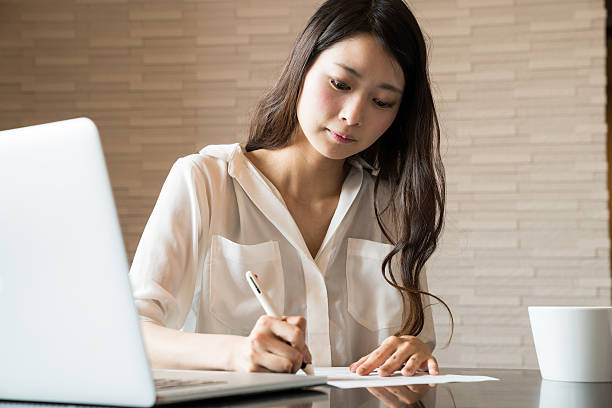 Image of a lady filling out a Greece resident permit application form after moving to Greece