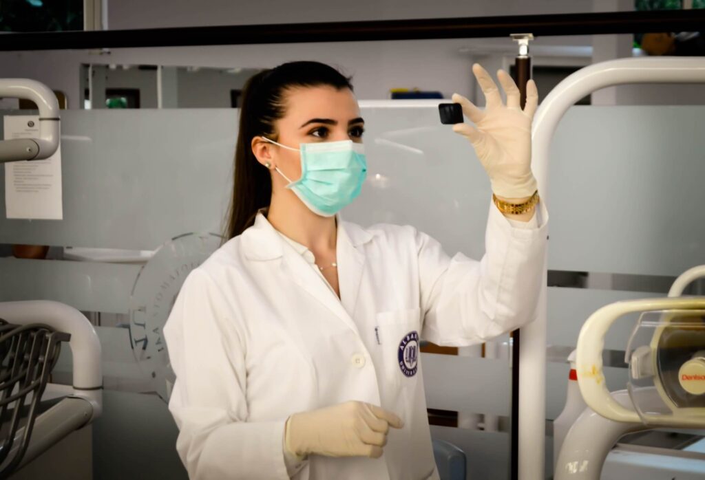 A laptop scientist wearing a white laboratory coat, doing the blood work of a patient with a pre-existing condition.