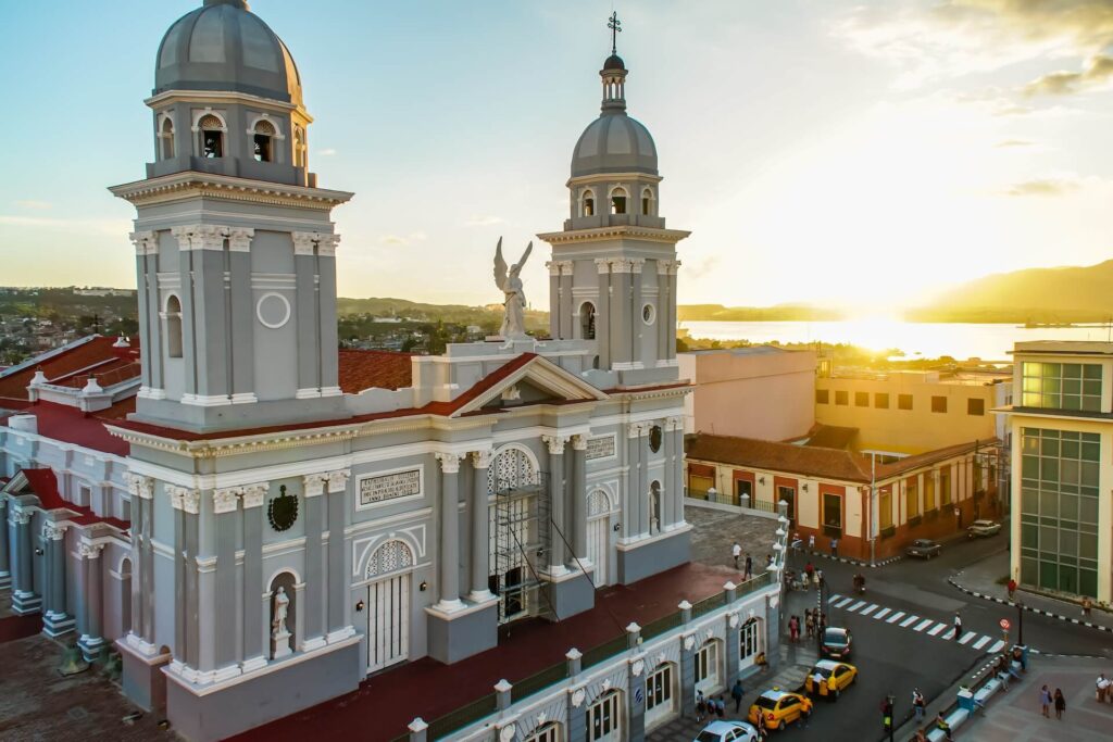 A cathedral in Santiago de Cuba with taxis driving around it