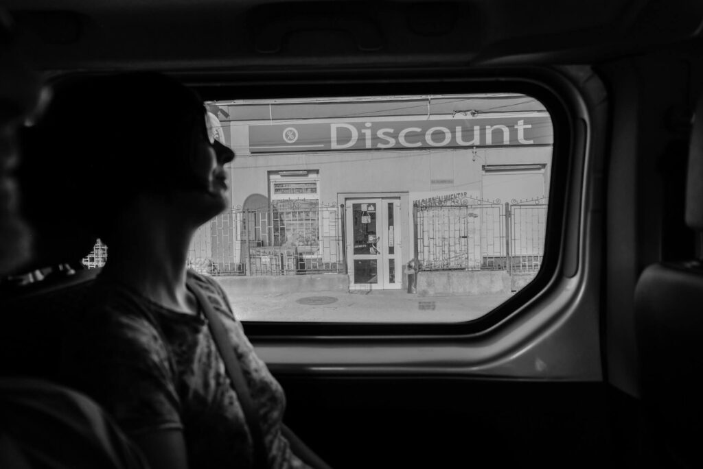 A lady on a train moving past a business offering massive discounts