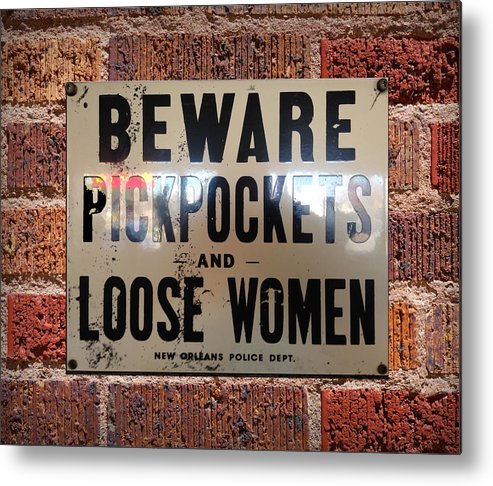 A sign that reads; "beware of pickpockets and loose women