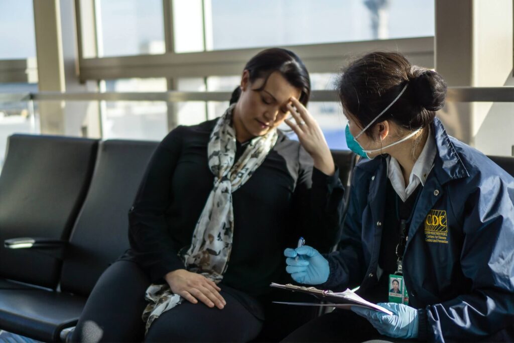 A cdc official asking a traveler who looks sick some questions