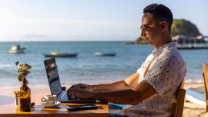A digital nomad working by the beach